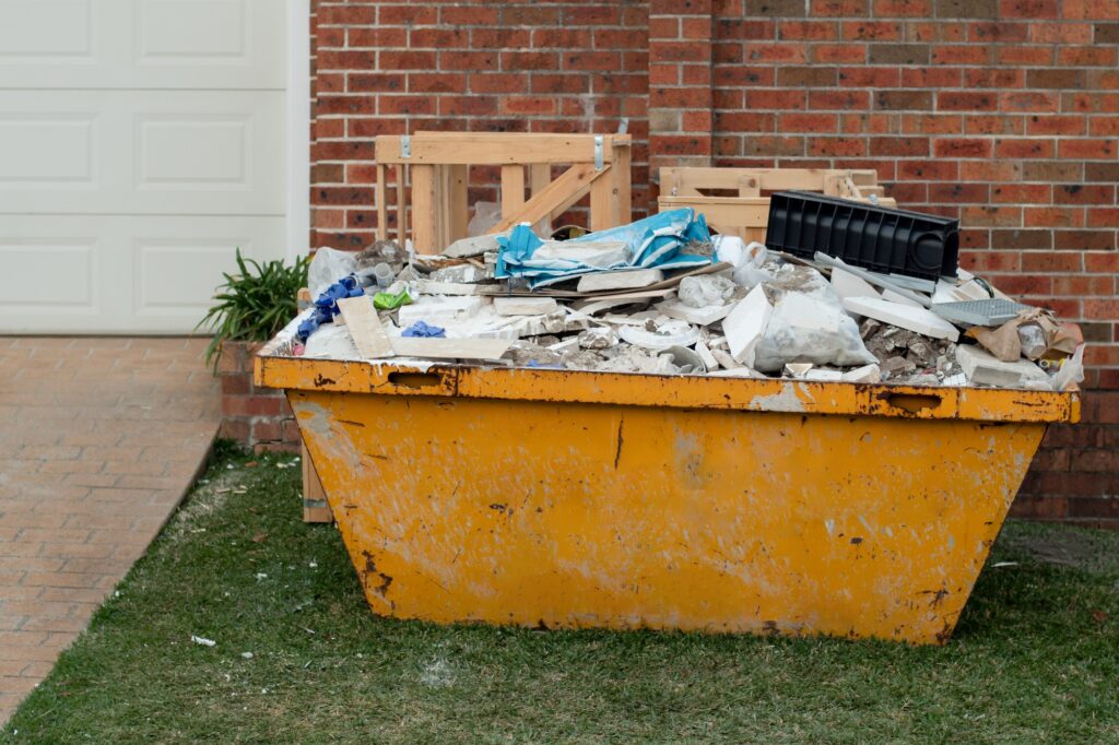 Skip bin full of household waste rubbish. House clean up and renovation concept. Waste management